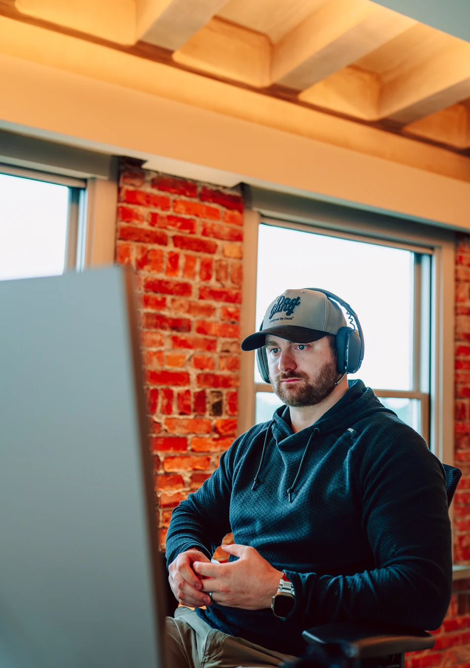 A Stick & Tin team member wearing a headset at his desk